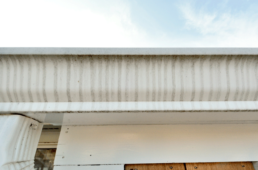 Tiger striping on a white gutter from rain overspill.