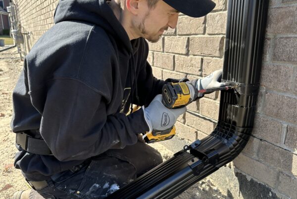 Black 3x4 Downspout being installed with downspout hinge