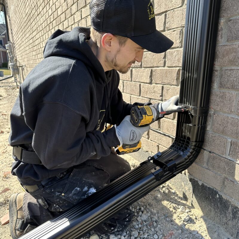 Black 3x4 Downspout being installed with downspout hinge