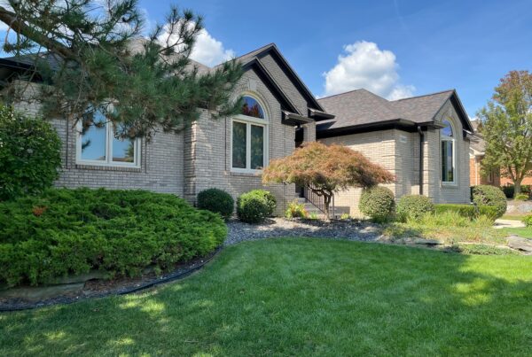 large beige brick home with black gutters
