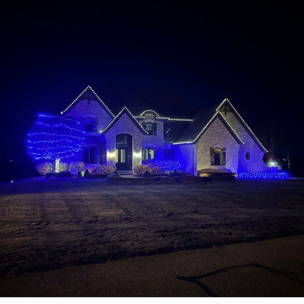 Grey brick home with white and blue lights