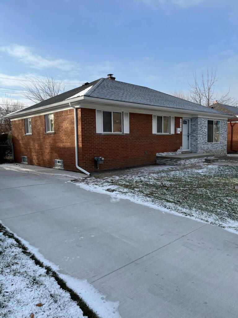Red brick home with white seamless gutters