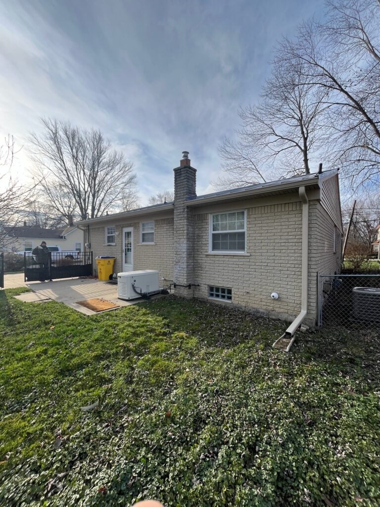 Beige brick home with shell gutters