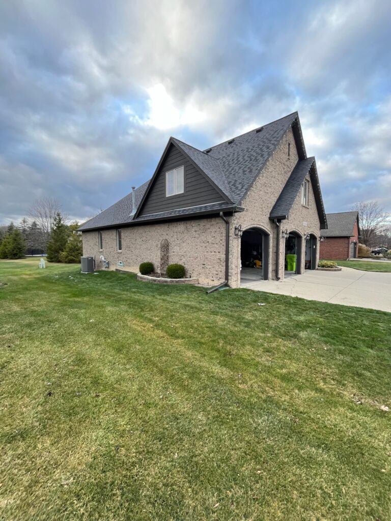 Brown brick home with black gutters