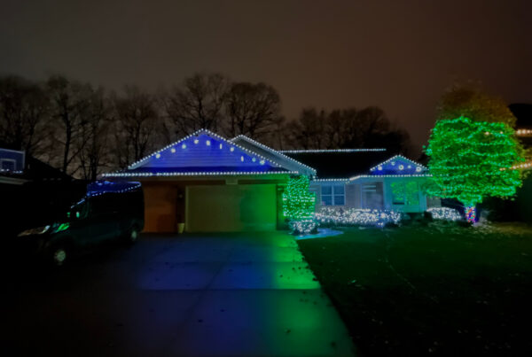 House with white, blue and green holiday lights
