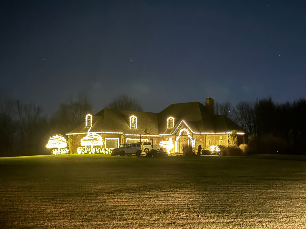 Large brick home with white holiday lights