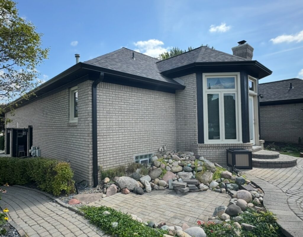 Grey brick home with black gutters