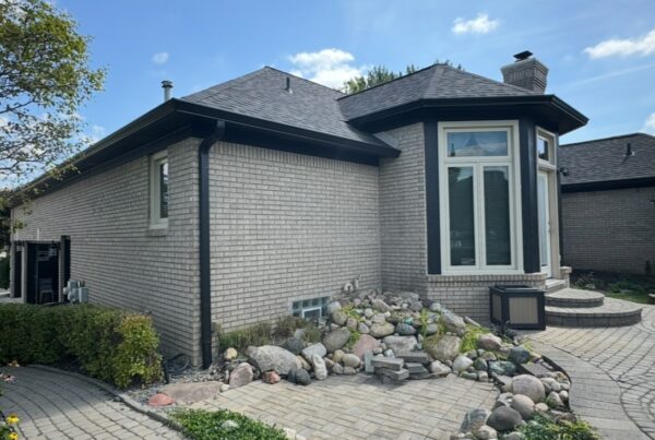 Grey brick home with black gutters