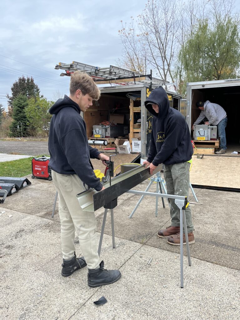 two men working with trailers behind them with a man inside
