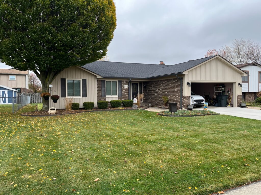 brown brick home with beige siding