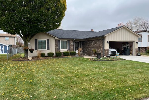 brown brick home with beige siding