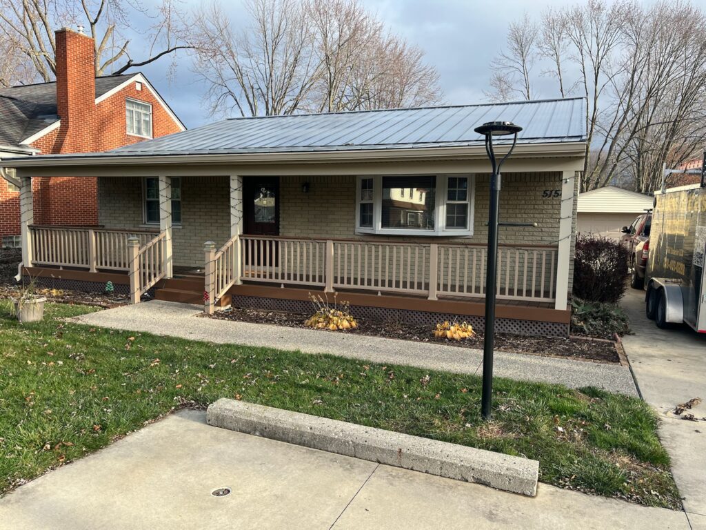small beige sided home with clay gutters