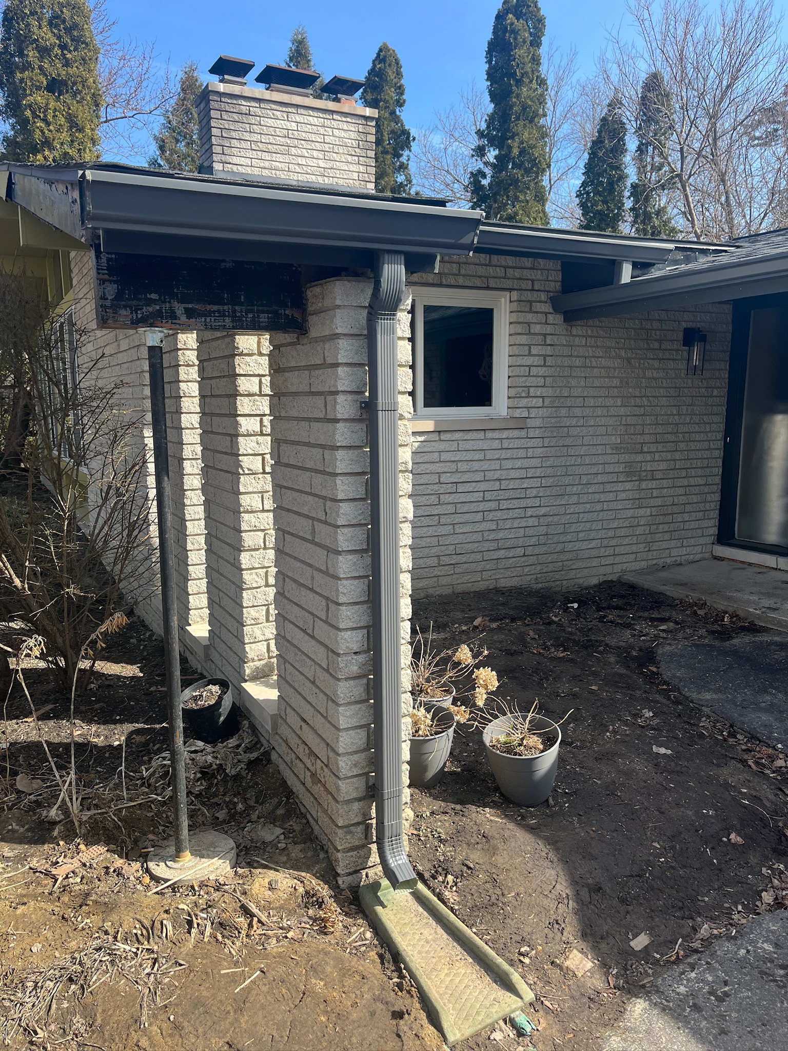 white brick home with black gutters