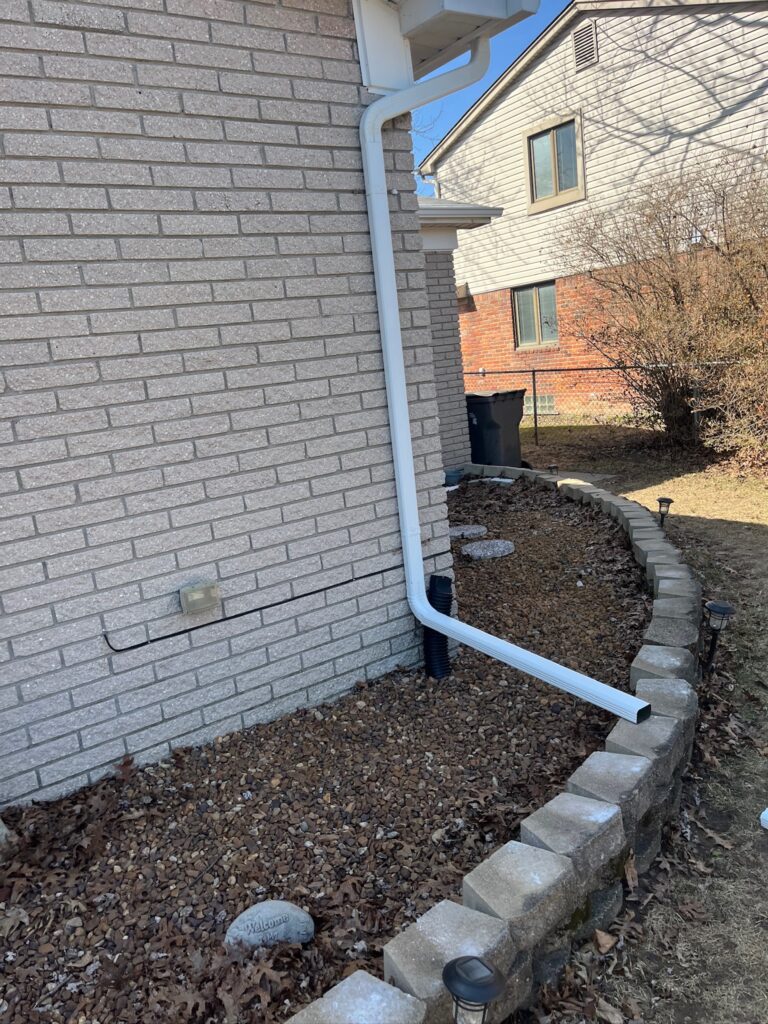 white brick home with white downspout