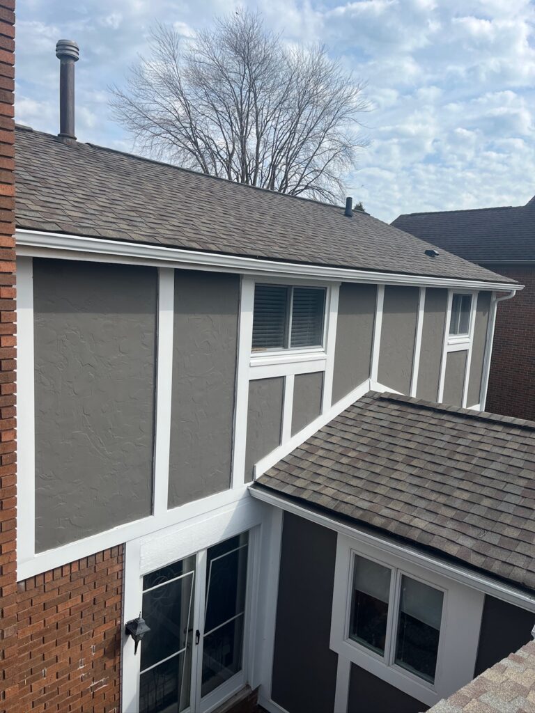 red brick home with gray and white siding
