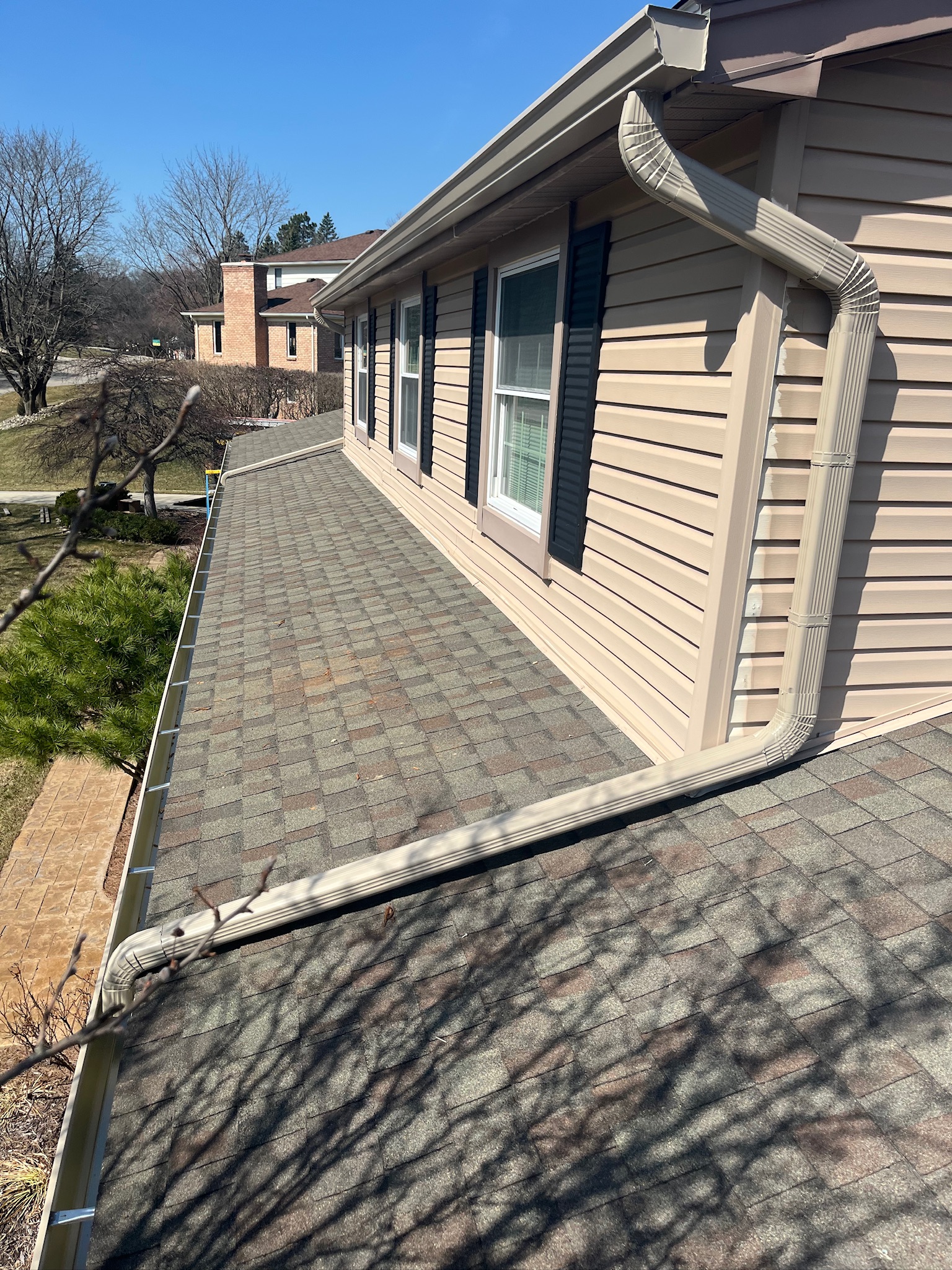 beige home with second story downspout