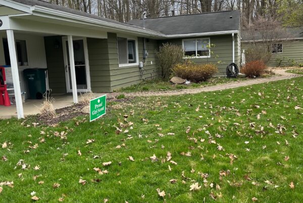 green sided one story home with white gutters