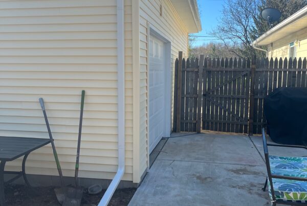 yellow sided home with white downspout