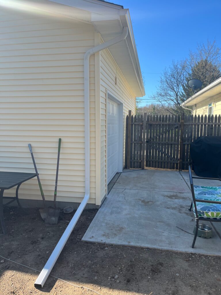 yellow sided home with white downspout