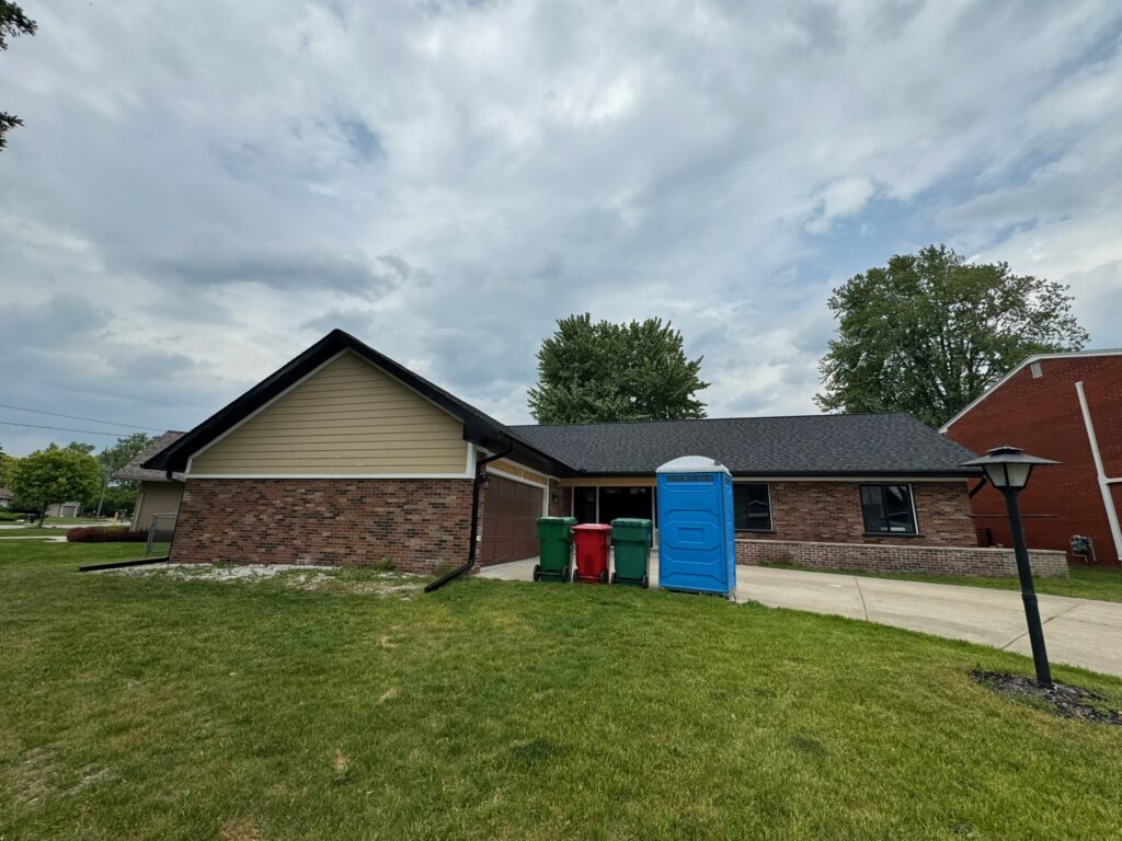 red brick one story home with black roof