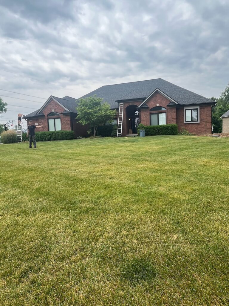 brown brick home with black roof